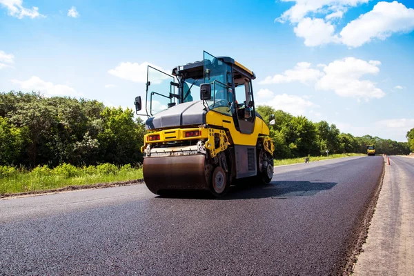 industrial landscape with rollers that rolls a new asphalt in th