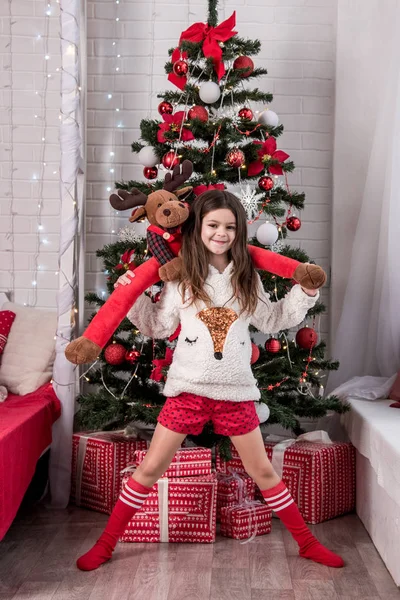 Bella giovane madre con sua figlia sorridente guardando Christm — Foto Stock