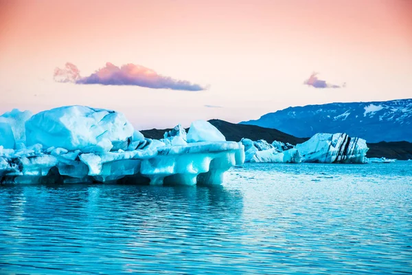 Magical landscape with ice depths in famous Jokulsarlon glacial lagoon in Iceland at sunset, global warming  concept