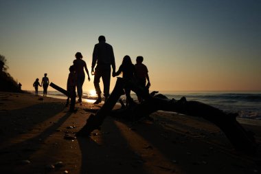 Aile sabahın erken saatlerinde sahilde yürür.