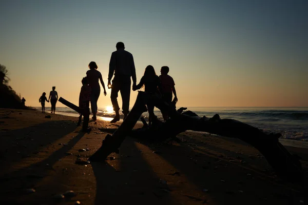 Aile sabahın erken saatlerinde sahilde yürür.