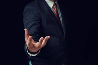 Siyah takım elbiseli, el ele tutuşan bir iş adamı. Kavram, iş, sanayi, siyah arkaplanda başarı.