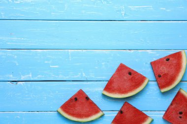 Fotokopi alanı olan mavi ahşap arka planda karpuz renkli dilimler. Yaz konsepti.