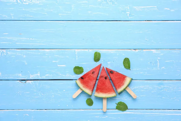 Nane şekerli karpuz dilimi, mavi ahşap masa arkaplanındaki yaz meyveleridir..