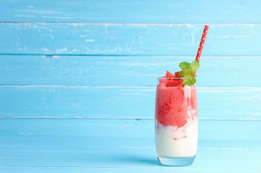 Soğuk karpuz suyu smoothie karışık yoğurt ferahlatıcı içecek sağlıklı bir yaz için mavi arka planda fotokopi alanı ile birlikte.
