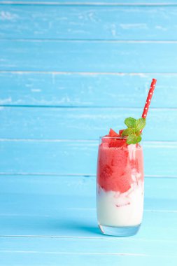 Soğuk karpuz suyu smoothie karışık yoğurt ferahlatıcı içecek sağlıklı bir yaz için mavi arka planda fotokopi alanı ile birlikte.