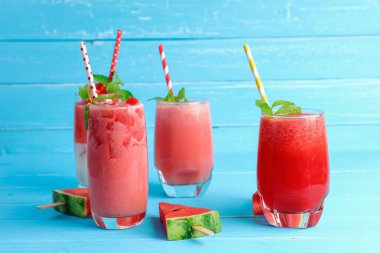 Mavi ahşap arka planda, fotokopi alanı olan bardakta karpuz içeceği var. İçkiler yazın sağlığına iyi gelir..