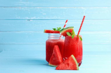 İçkiler yazın sağlığına iyi gelir. Mavi ahşap arka plandaki bardakta fotokopi alanı olan soğuk karpuz smoothie içecekleri..