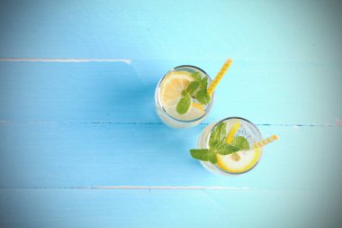 Yaz tatili. Meyve içecekleri. Limon suyu, alkolsüz soda, kaygan limon ve nane şekerini mavi ahşap arka planda fotokopi aletiyle karıştırıyor. Bu yaz sağlığa içelim..
