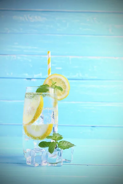 レモン汁ソーダのアルコールとスライドレモンとミントをガラスの青木製の背景にコピースペースで混合します この夏の健康のための飲み物 — ストック写真