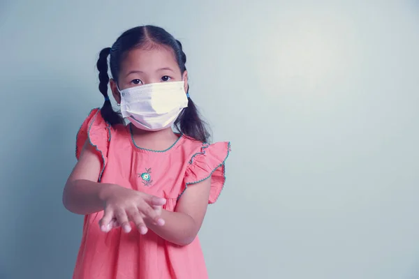 Азиатская Девочка Носит Медицинскую Маску Очищая Руки Используя Алкогольный Гель — стоковое фото