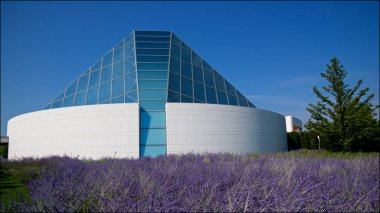 Cam malzeme piramidi olan modern bir binanın yan görüntüsü