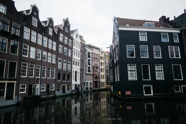 Amsterdam 'da insanlar ve tekneler olmadan su kanalı. Hollanda 'da güzel koyu tuğlalı binalar. 