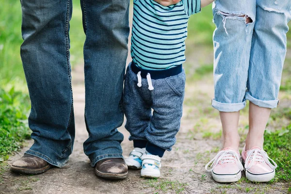Le gambe dei padri mamma e figlio piccolo. Una passeggiata in famiglia nella natura . — Foto Stock
