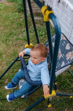 Bahçedeki bebek arabasında güzel bir beyaz çocuk.