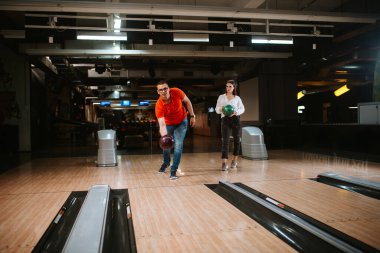 Bovling salonunda top atan güzel beyaz bir çift. Bowling kulübündeki erkek arkadaş ve kız arkadaş