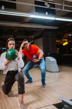 Bovling salonunda top atan güzel beyaz bir çift. Bowling kulübündeki erkek arkadaş ve kız arkadaş