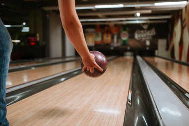 Bir bowling kulübünde top atan beyaz bir adamın elini yakın plan çek.