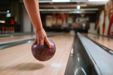 Bir bowling kulübünde top atan beyaz bir adamın elini yakın plan çek.