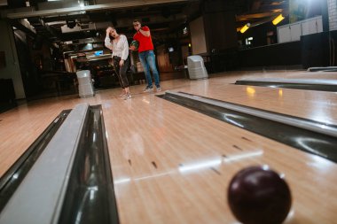 Bovling salonunda top atan güzel beyaz bir çift. Bowling kulübündeki erkek arkadaş ve kız arkadaş