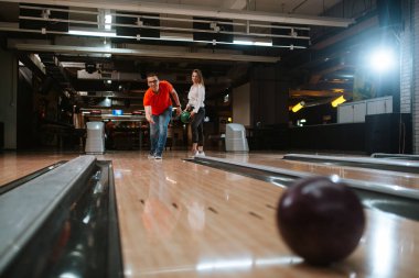 Bovling salonunda top atan güzel beyaz bir çift. Bowling kulübündeki erkek arkadaş ve kız arkadaş