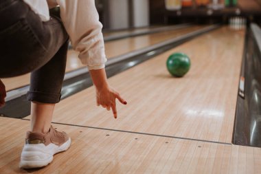 Bir bowling kulübünde top fırlatırken Kafkasyalı genç bir kızın elini kapat.