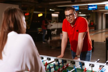 Güzel beyaz bir kız ve gözlüklü bir adam oyun odasında futbol oynuyor. Aşk ve eğlence zamanı