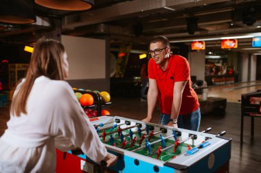 Güzel beyaz bir kız ve gözlüklü bir adam oyun odasında futbol oynuyor. Aşk ve eğlence zamanı