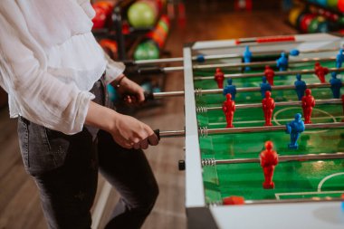 Masa futbolu oynarken beyaz gömlekli beyaz bir kadının ellerini yakın plan çek. Eğlence zamanı.