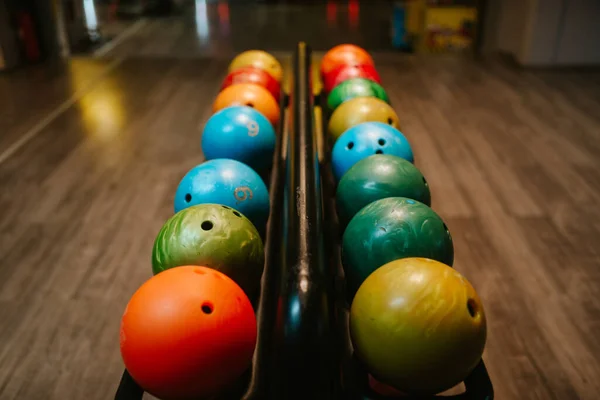 Multicolored bowling balls on the shelf in the bowling club