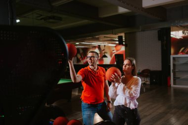 Güzel bir beyaz kadın ve bir erkek oyun odasında basketbol oynuyorlar. Aşk ve eğlence.