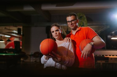 Güzel bir beyaz kadın ve bir erkek oyun odasında basketbol oynuyorlar. Aşk ve eğlence.
