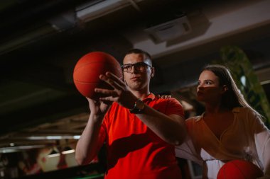 Güzel bir beyaz kadın ve bir erkek oyun odasında basketbol oynuyorlar. Aşk ve eğlence.