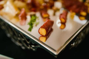 Ananas bir tepside prosciutto ile sarılmış.