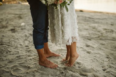 Gelinin ve damadın ayakları kumsalda kumsalda