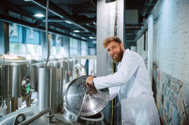 Üretim fabrikasındaki endüstriyel süreci kontrol eden Kafkas Teknoloji Uzmanı. Koruyucu üniformalı sanayi işçisi gıda fabrikasındaki verimliliği kontrol ediyor..