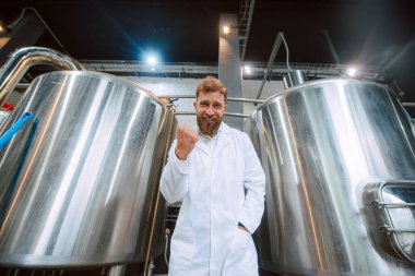  İlaç veya gıda fabrikasında duran beyaz üniforma konusunda uzman beyaz tenli yakışıklı teknoloji uzmanının portresi.