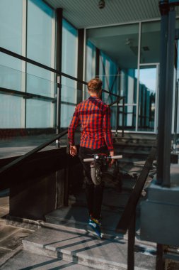 Şehirde elektrikli scooter kullanan yakışıklı bir adam.