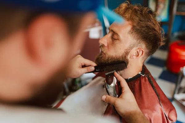 Närbild Händerna Frisör Som Trimmar Ung Kaukasisk Mans Skägg Nytt — Stockfoto