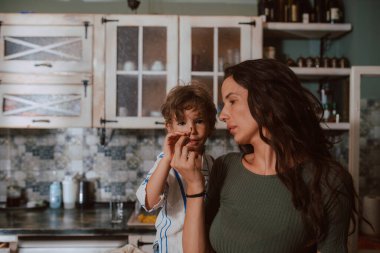 Güzel beyaz bir anne, oğlunu mutfakta besler. Aileyle zaman geçirmek