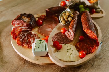 Özel bir etkinlik için tabakta servis edilen lezzetli aperatifler. Parti konukları için aperatifler. Şarküteri tahtası