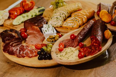 Özel bir etkinlik için tabakta servis edilen lezzetli aperatifler. Parti konukları için aperatifler. Şarküteri tahtası