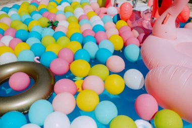 Havuz balonları ve pembe flamingolarla çok güzel dekore edilmiş bir bahçe. Bir yaz partisi için bahçe süslemesi