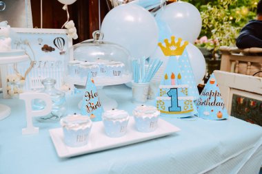 Küçük bir çocuğun birinci yaş günü için çok güzel dekore edilmiş tatlı bir masa.