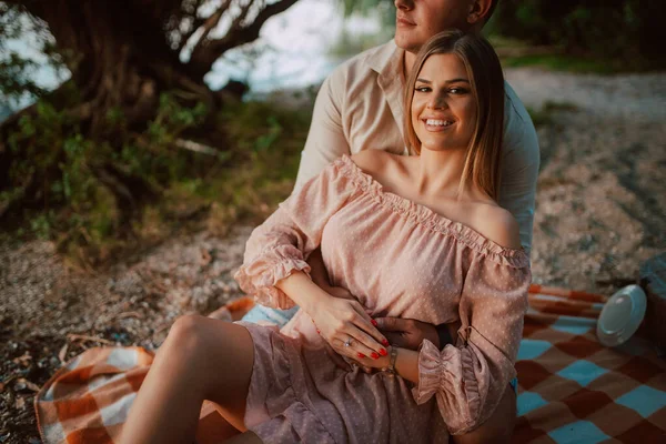魅力的なブロンドの白人女性はビーチの男の腕の中にあります 川のピクニックで愛しのカップル — ストック写真
