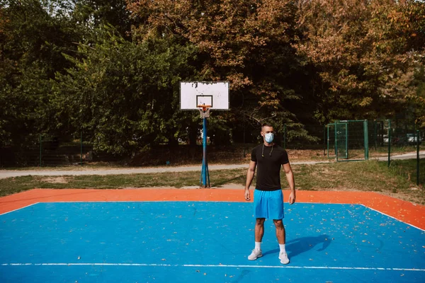 Plná Délka Svalnatého Bělošského Atleta Zdravotní Obličejovou Maskou Stojící Venkovním — Stock fotografie