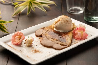 Krep ve karamelli dulce de leche dolgu ve ahşap masada vanilyalı dondurma.