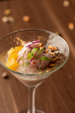 Kokteyl bardağında ceviche Peru usulü güzel bir akşam yemeği - limon suyu mısır ve kırmızı soğanlı balık