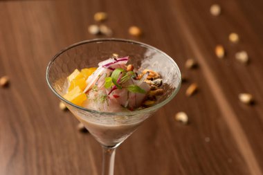 Kokteyl bardağında ceviche Peru usulü güzel bir akşam yemeği - limon suyu mısır ve kırmızı soğanlı balık