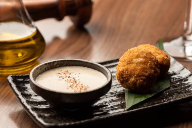 Peynirle doldurulmuş kızarmış toplar ve arka planda bulanık Tayland yemeğiyle kızartılmış soslar.
